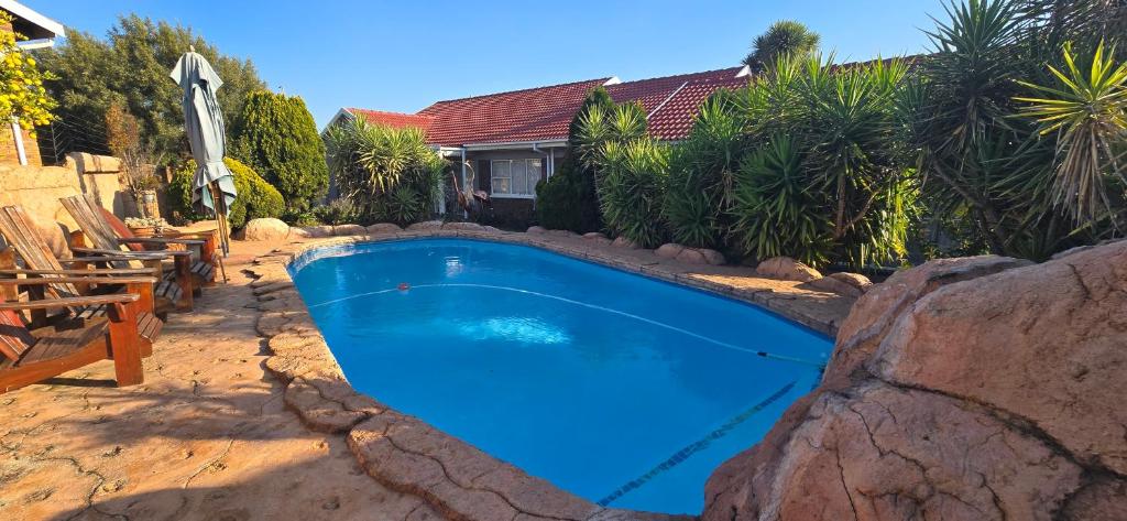 a blue swimming pool in front of a house at GerSan Oasis in Nigel