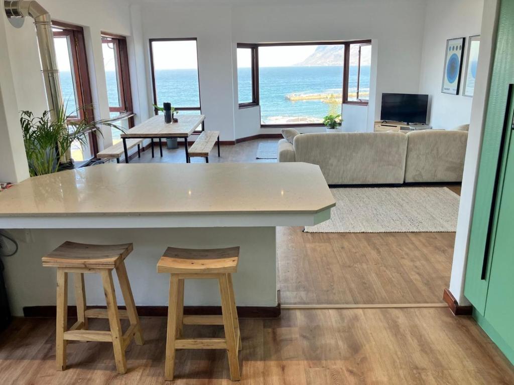a living room with a table and two stools at The Lookout - Spacious 2 bed overlooking Kalk Bay in Kalk Bay