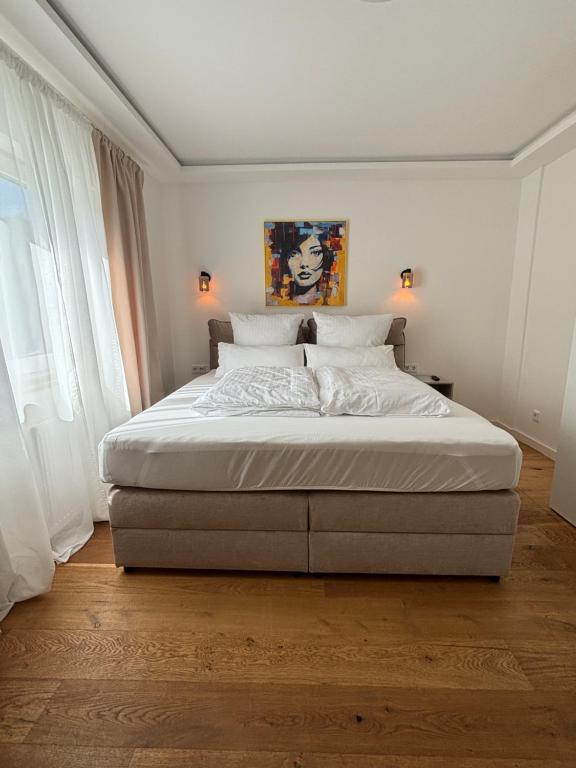 a large bed in a bedroom with white walls at Hygge in Neumünster