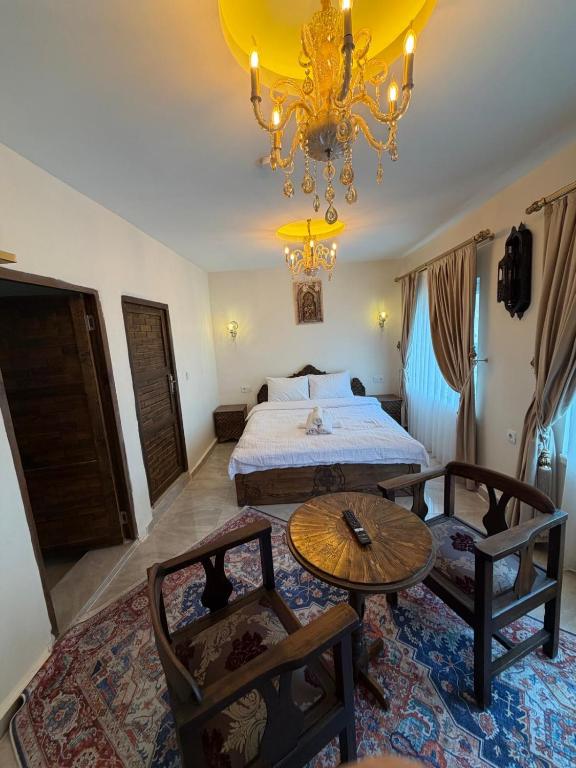 a bedroom with a bed and a table and chairs at Mardin Kent Suit Hotel in Mardin