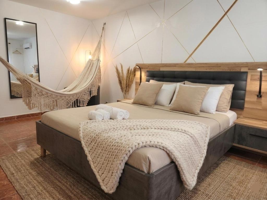 a bedroom with a large bed and a hammock at Bougainvillea House in Ponta do Pargo
