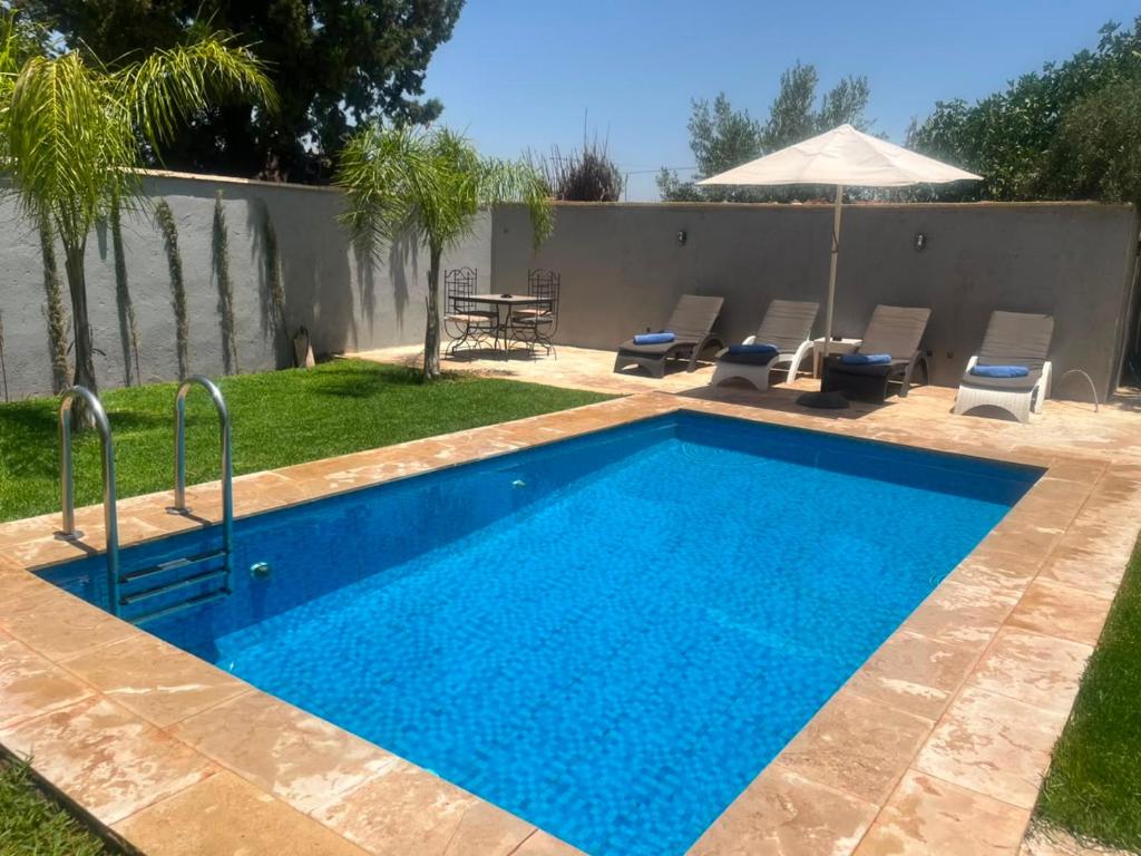 a swimming pool in the backyard of a house at Riad Elbahi in Marrakesh