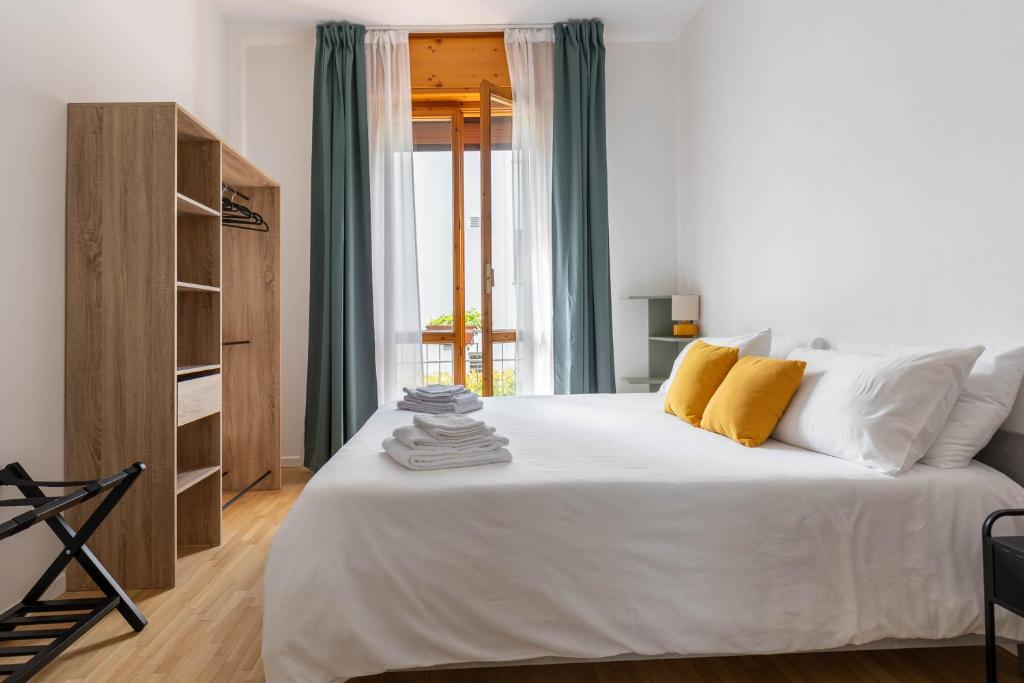 a bedroom with a large white bed with yellow pillows at Casa Orlando in Modena