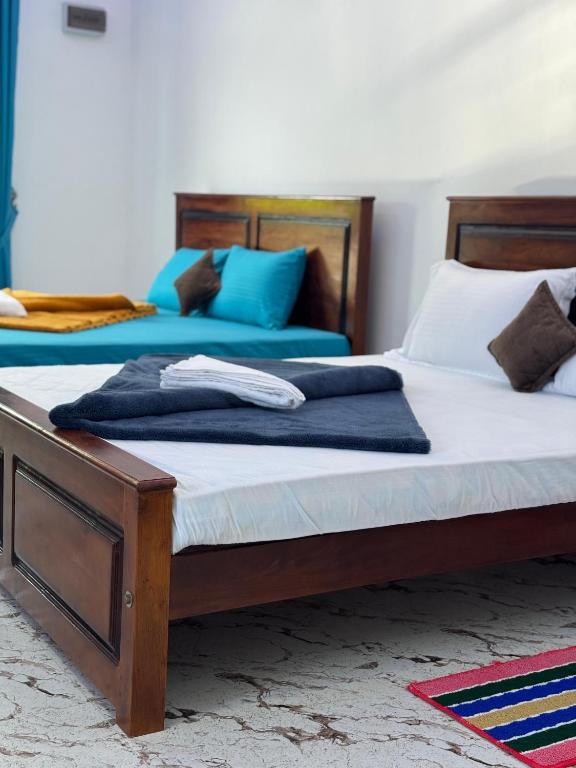 two beds in a bedroom with blue and white at Bhanuka Hevan Place in Ella