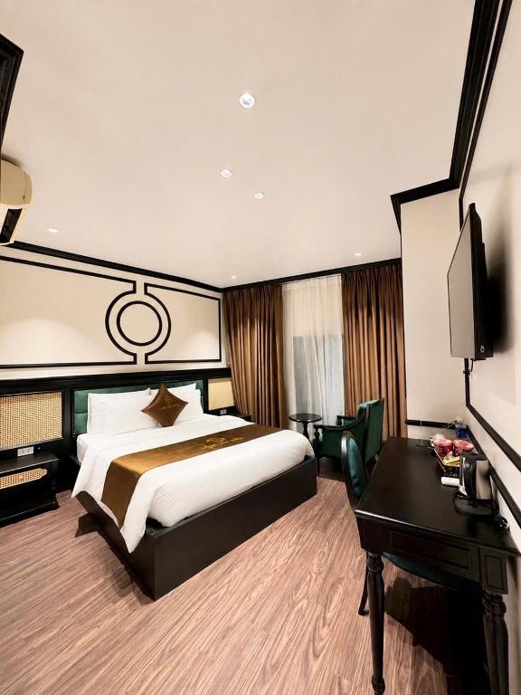 a bedroom with a bed and a desk and a television at Giang Son Hanoi Hotel in Hanoi
