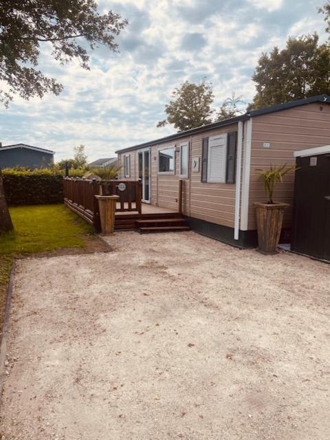 a small house with a patio next to a yard at Chalet tussen Zee en Meer in Lauwersoog