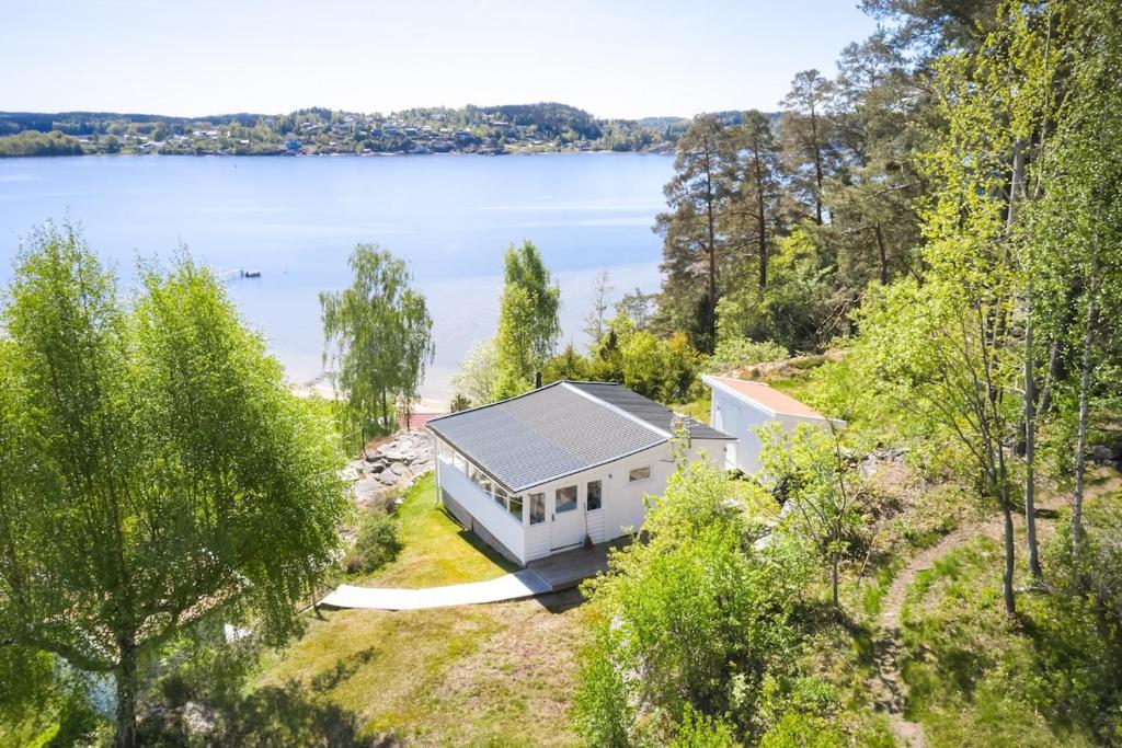 an aerial view of a white house on the shore of a lake at Sea View cottage with 2 sleeping cabins in Uddevalla
