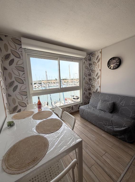 a living room with a table and a couch at Studio cosy climatisé vue sur port in Cap d'Agde