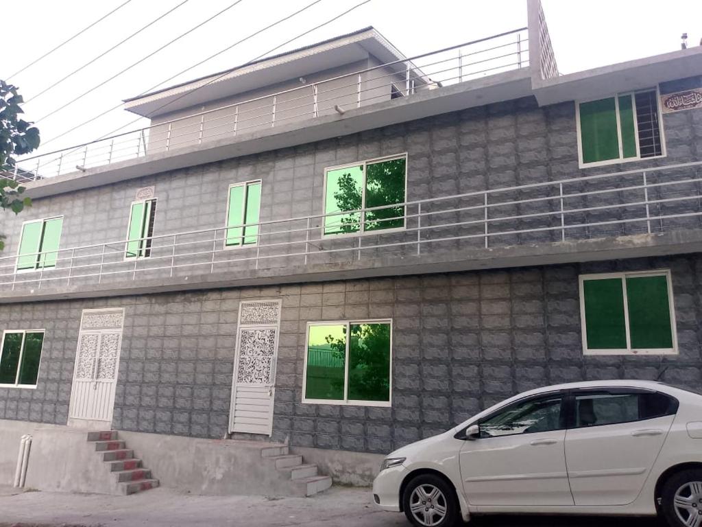 a white car parked in front of a building at Dream suits in Lower Topa