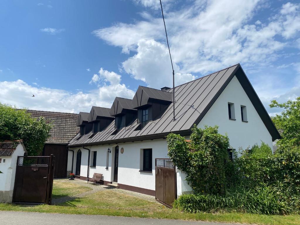 a white house with a black roof at Chalupa Obora in Cerhonice