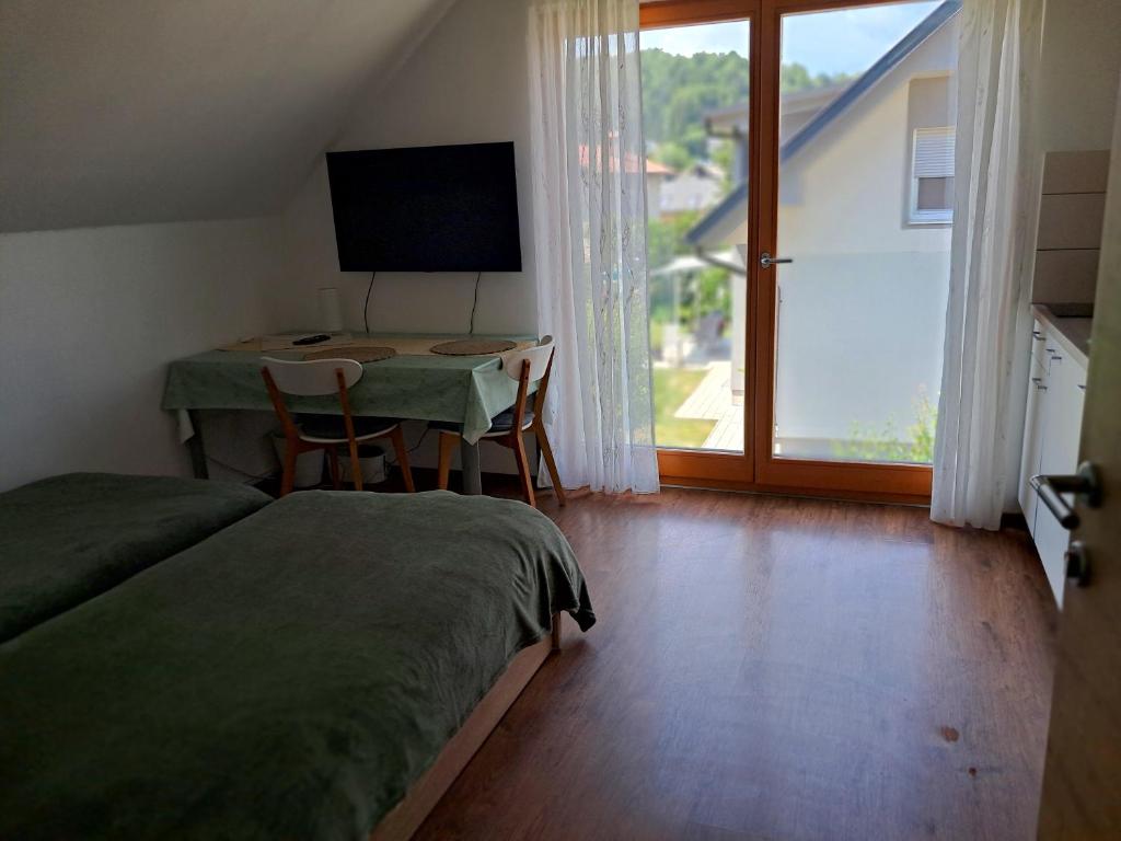 a bedroom with a desk and a table with a television at Mountain view in Medvode