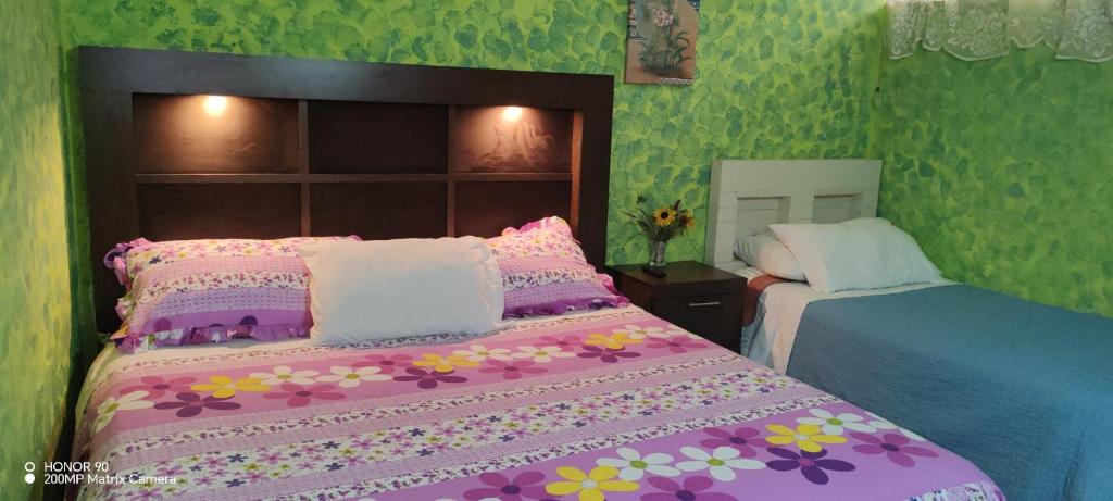 a bedroom with a pink bed with flowers on it at Casamar in Cobán