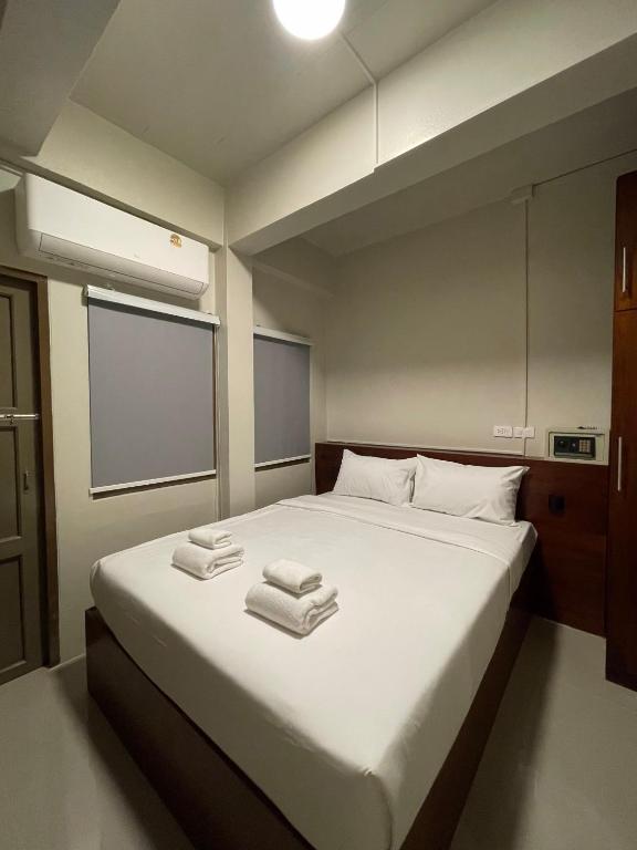 a bedroom with a large bed with towels on it at ON'S Place in Pattaya