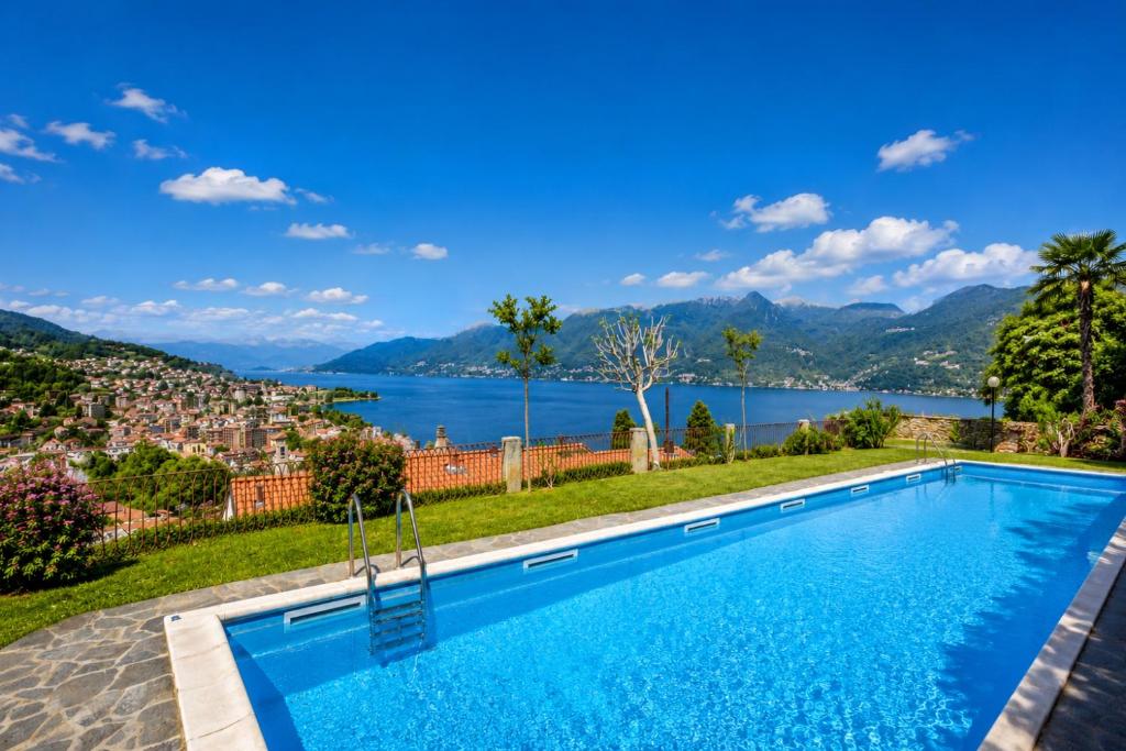 a swimming pool with a view of a lake and mountains at La Perla del Lago in Luino