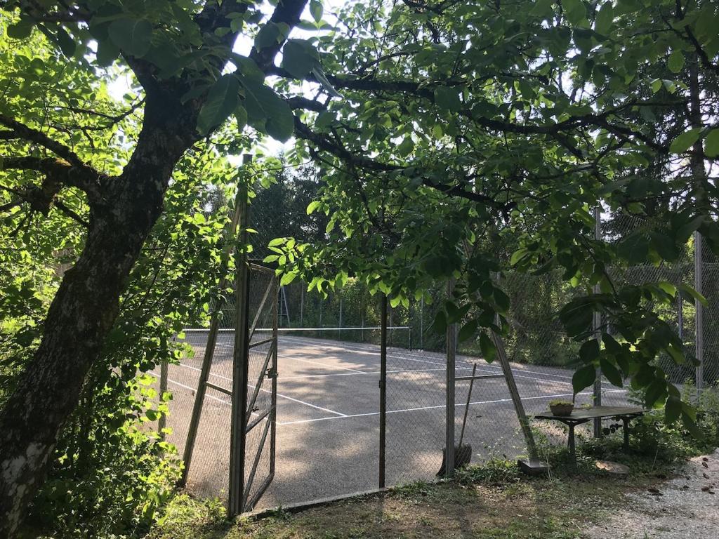 a tennis court with a tennis net and a bench at Studio Tennis Riviere in Annecy