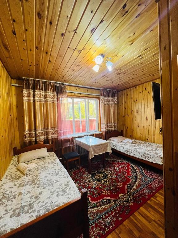 ein Zimmer mit zwei Betten und einem Tisch darin in der Unterkunft Argali hotel in Bügat