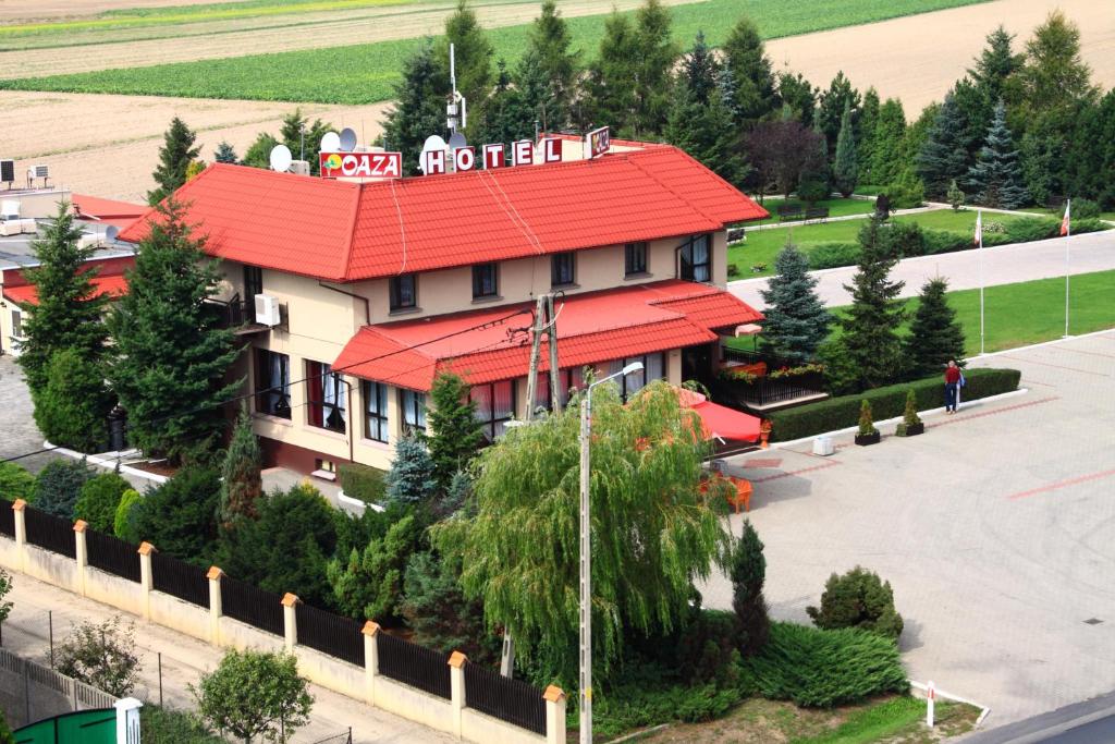 een gebouw met een rood dak op een straat bij Hotel Oaza in Golina