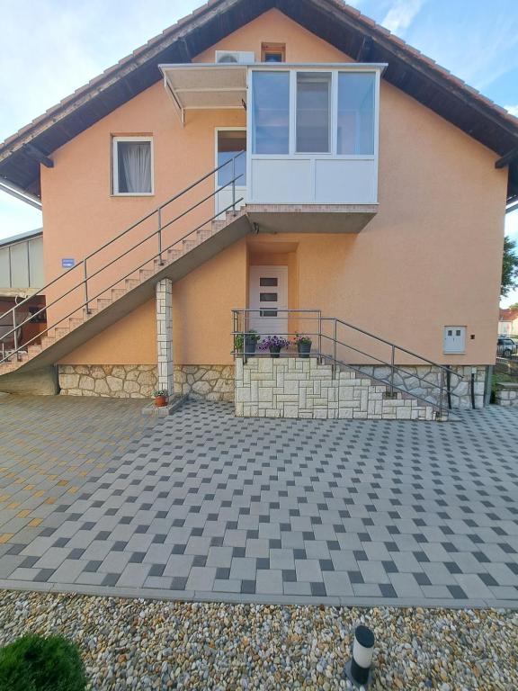 a house with a staircase and a balcony at Apartman Vučedolski san in Vukovar