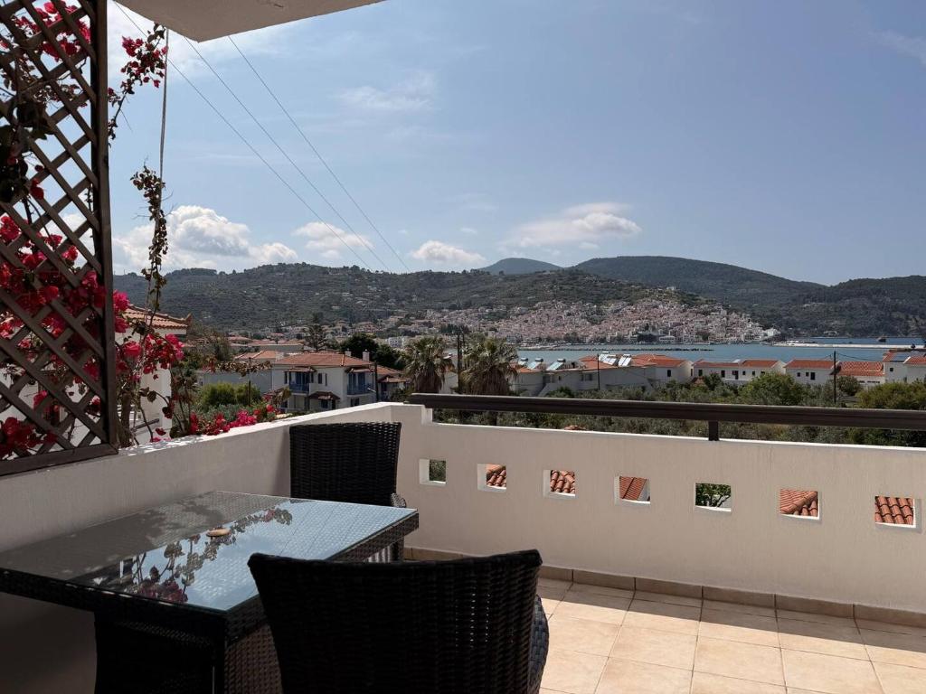 a balcony with a table and chairs and a view at Cozy Aegean Escape in Skopelos Town