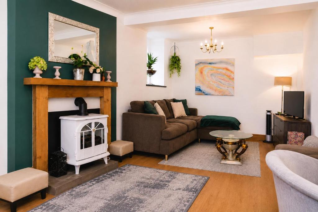 a living room with a couch and a fireplace at Walk to Town, Parking, Family Home, drive to beach in Bridgend