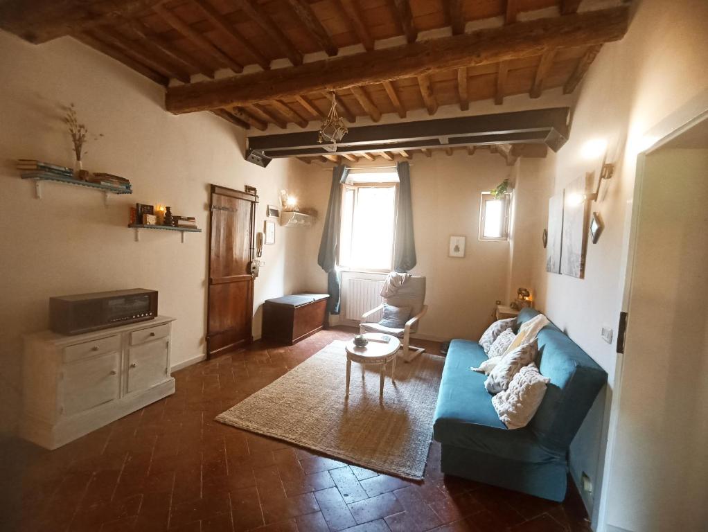 a living room with a blue couch and a chair at Il sogno di Tania in Pescia