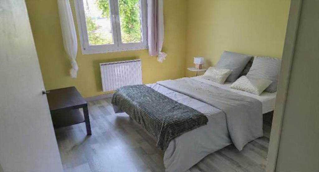 a bedroom with a large bed and a window at Samedi soir au calme in Val De Livre
