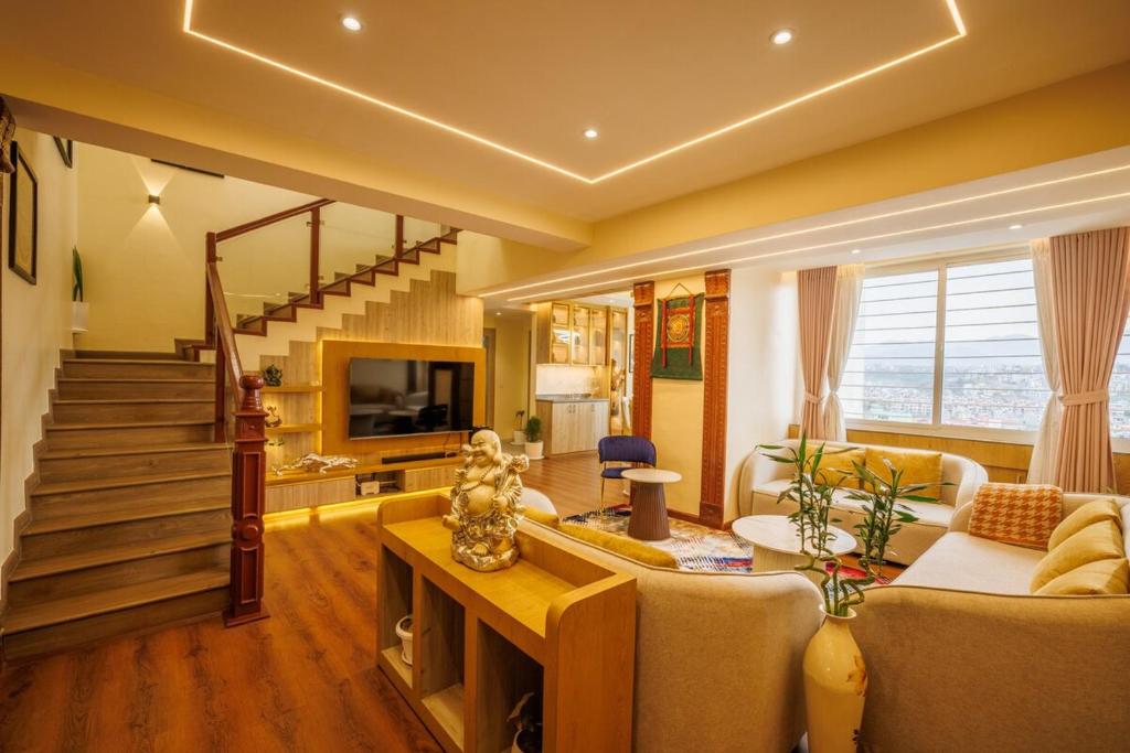 a living room with a couch and a staircase at Himalayan Heights Penthouse in Pātan