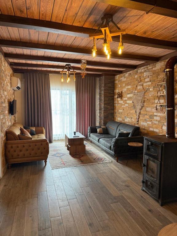 a living room with couches and a brick wall at Yeşilsu Taş Konağı in Yeşilsu