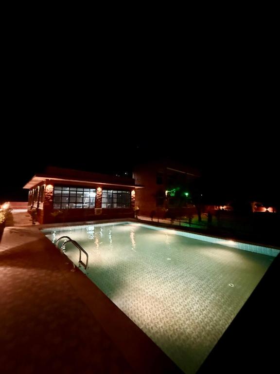 a large swimming pool at night with a building at Jawai Mount Town in Mori Bera