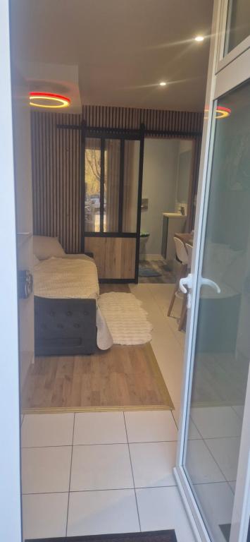 a bedroom with a bed and a sliding glass door at Studio meublé in Orsay