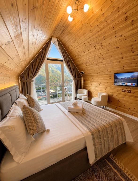 a bedroom with a large bed with a large window at Guest house Panorama in Koman