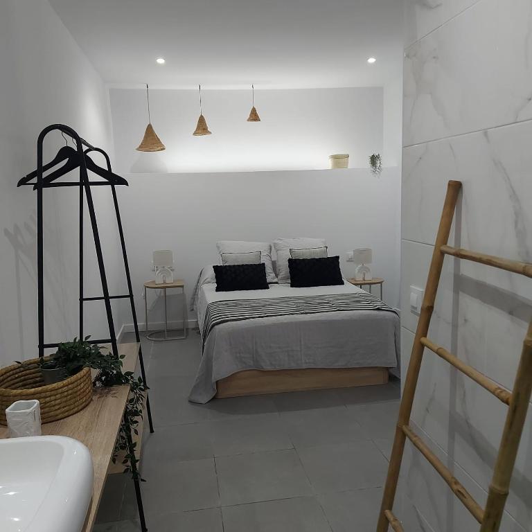 a white bedroom with a bed with black pillows at Casa de angil in Tivenys