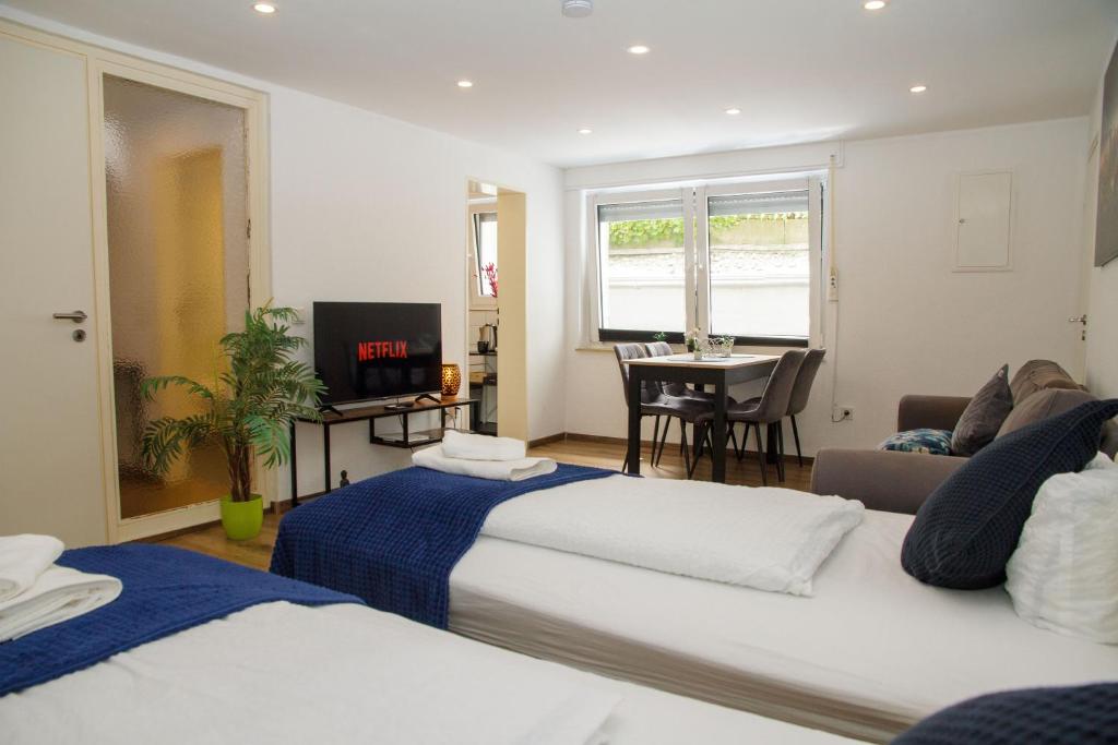 a hotel room with two beds and a table at Apartment für 3, 2 Boxspringbetten, Internet & Parkplatz in Dortmund