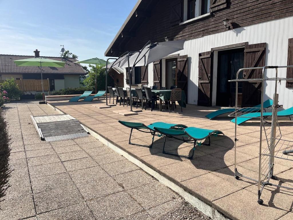 a patio with tables and chairs and a playground at Gîte les Lilas Blancs 15mn Gérardmer in Champdray