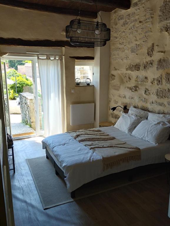 a bedroom with a large bed with a stone wall at Iglesias Emmanuelle in Pradines