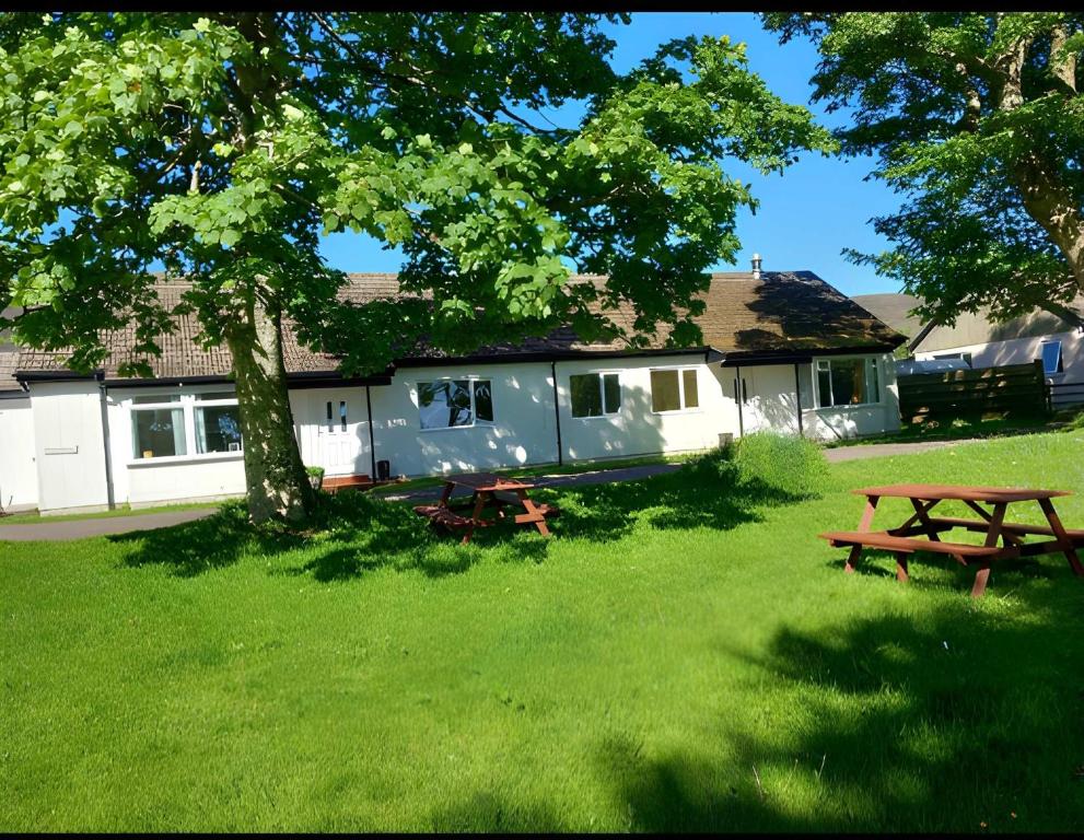 a house with two picnic tables in a yard at The Bunkhouse in Applecross