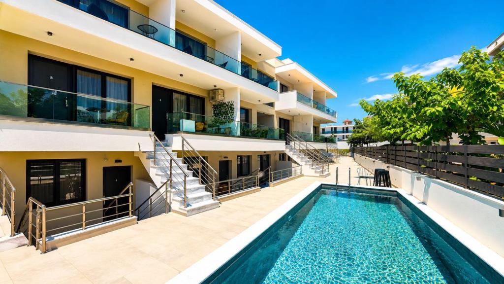 an apartment building with a swimming pool in front of a building at Ambra Luxury Suite 14 in Kallithea Halkidikis