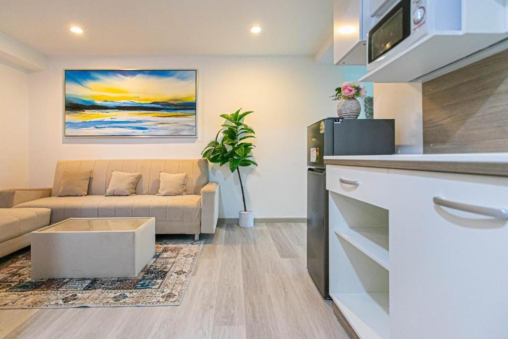a kitchen and a living room with a couch at Hin Nan Hua Hin RELAX in Hua Hin