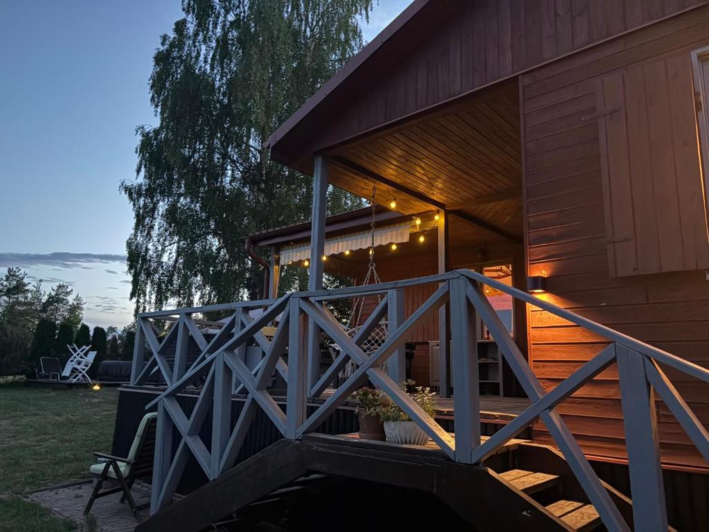 a wooden cabin with a porch and a deck at Amaleczka Woda Las in Podjazdy