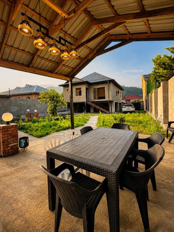 a wooden table and chairs under a wooden roof at Green dream House in Lankaran
