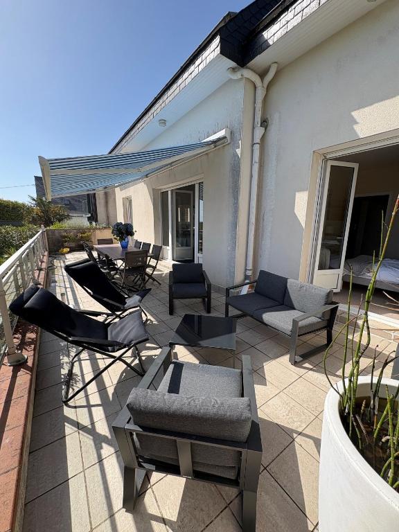 a patio with chairs and couches on a house at Ty avel in Crozon