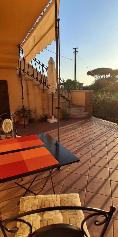 a patio with a table and an umbrella at Casa Adua in Donoratico