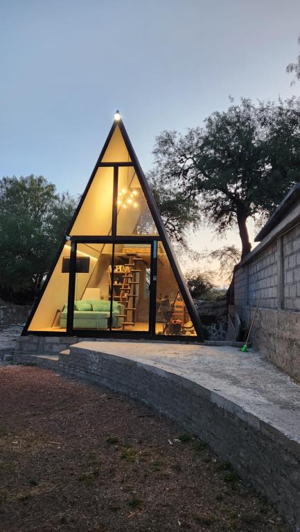 a glass house with a large window in the middle at Cabaña AlpinA Ixmiquilpan in Ixmiquilpan