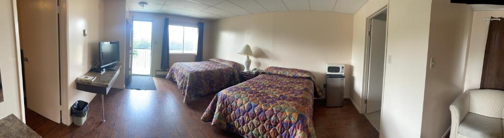 a hotel room with a bed and a tv at Pine Creek Motel in Waskatenau