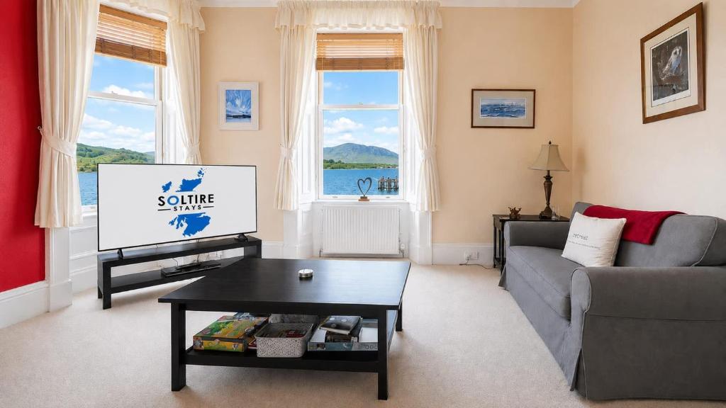 a living room with a couch and a tv at Ardyne House in Port Bannatyne