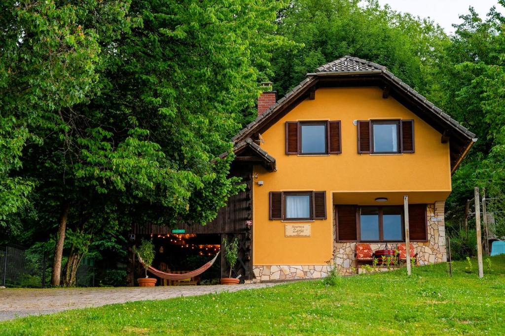 a yellow house with a tree at Apartment ZARJA in Dobrnič