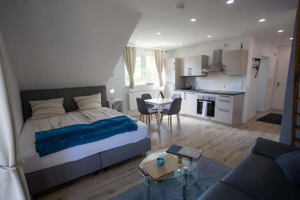 a bedroom with a bed and a living room at Reload Apartments - FeWo1 im Remmeker Feld in Bad Arolsen
