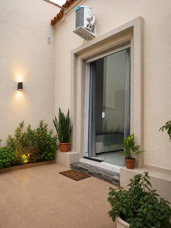 a room with a large window with plants in it at Quarto Privativo com ar condicionado no centro in Ribeirão Preto