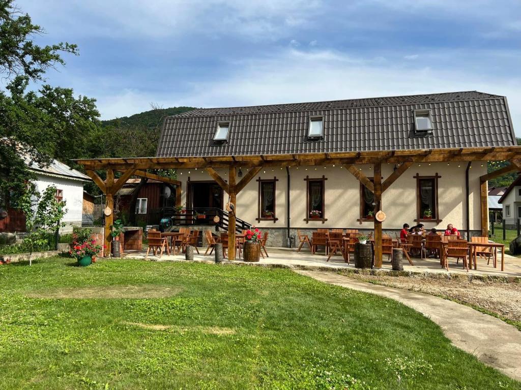 a pavilion with tables and chairs in front of a building at Magic Rooms in Gura Teghii