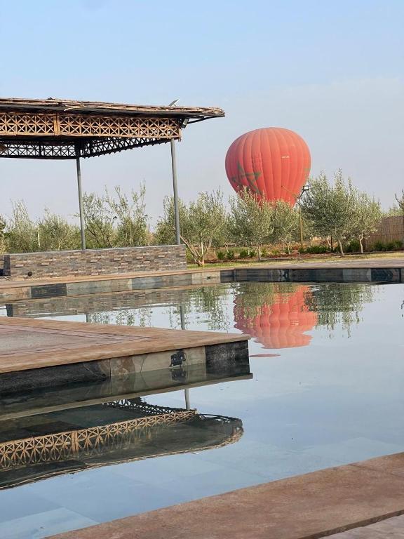 a reflection of two red lanterns in a pool of water at Le domaine de Koujane in Oulad el Guern